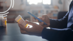 Patient using a smartphone to scan a prescription medication bottle during preoperative intake