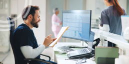 Surgery center leader reviewing a preoperative readiness dashboard with KPI charts on a laptop