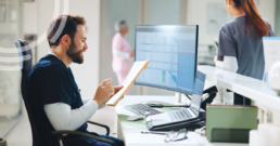 Surgery center leader reviewing a preoperative readiness dashboard with KPI charts on a laptop