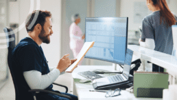 Surgery center leader reviewing a preoperative readiness dashboard with KPI charts on a laptop
